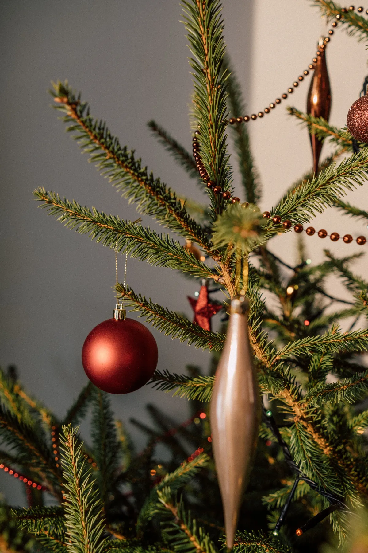 A beautifully adorned Christmas tree with elegant red and gold ornaments and glowing lights.