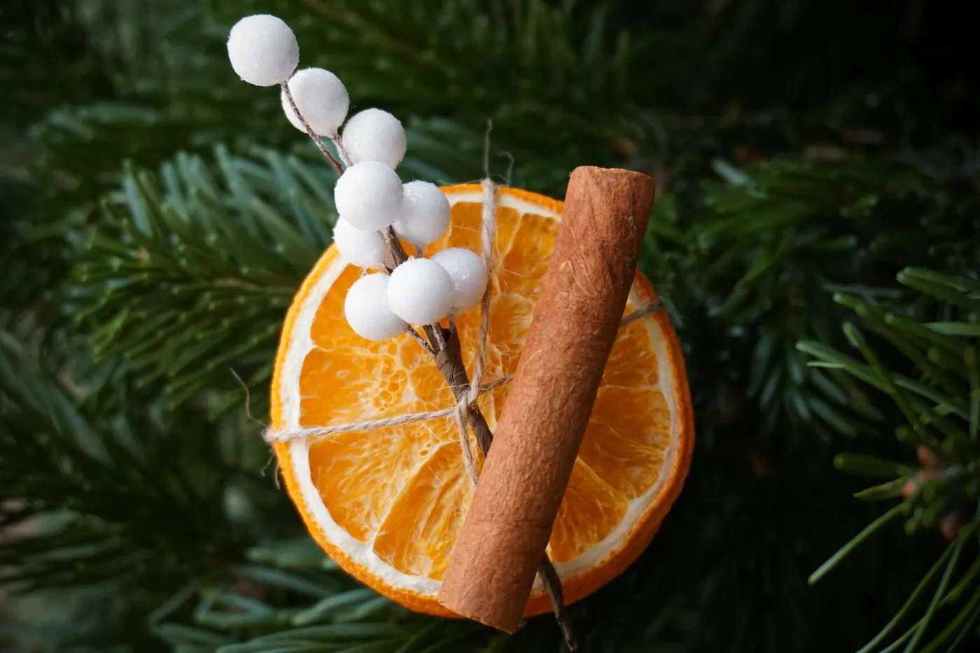 A cinnamon stick and an orange slice on a christmas ornament - Free Photo on Unsplash