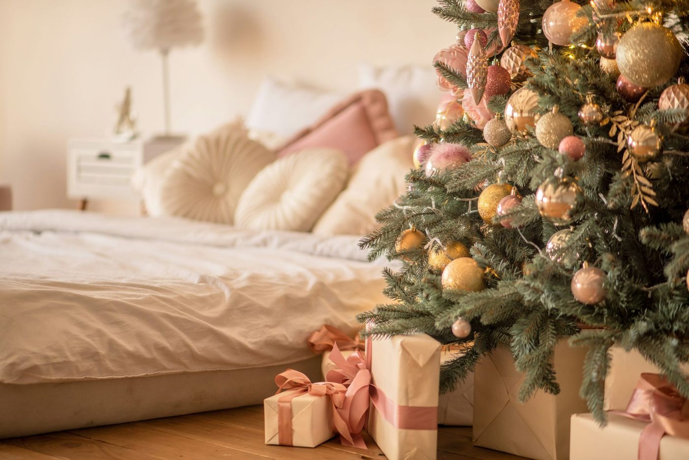 A decorated christmas tree in a bedroom next to a bed - Free Photo on  Unsplash