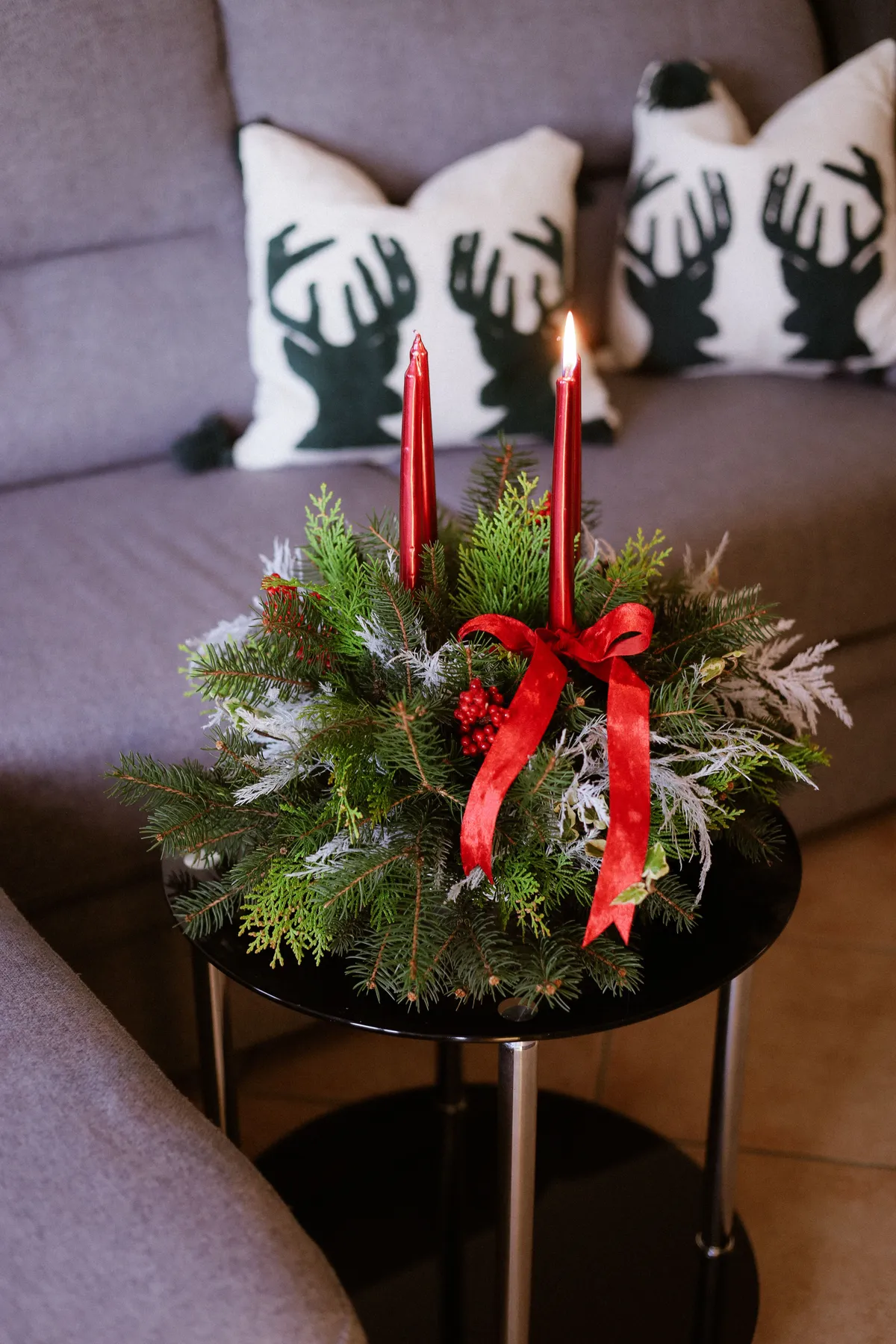 A festive Christmas candle arrangement adds warmth and cheer to a cozy living room setting.