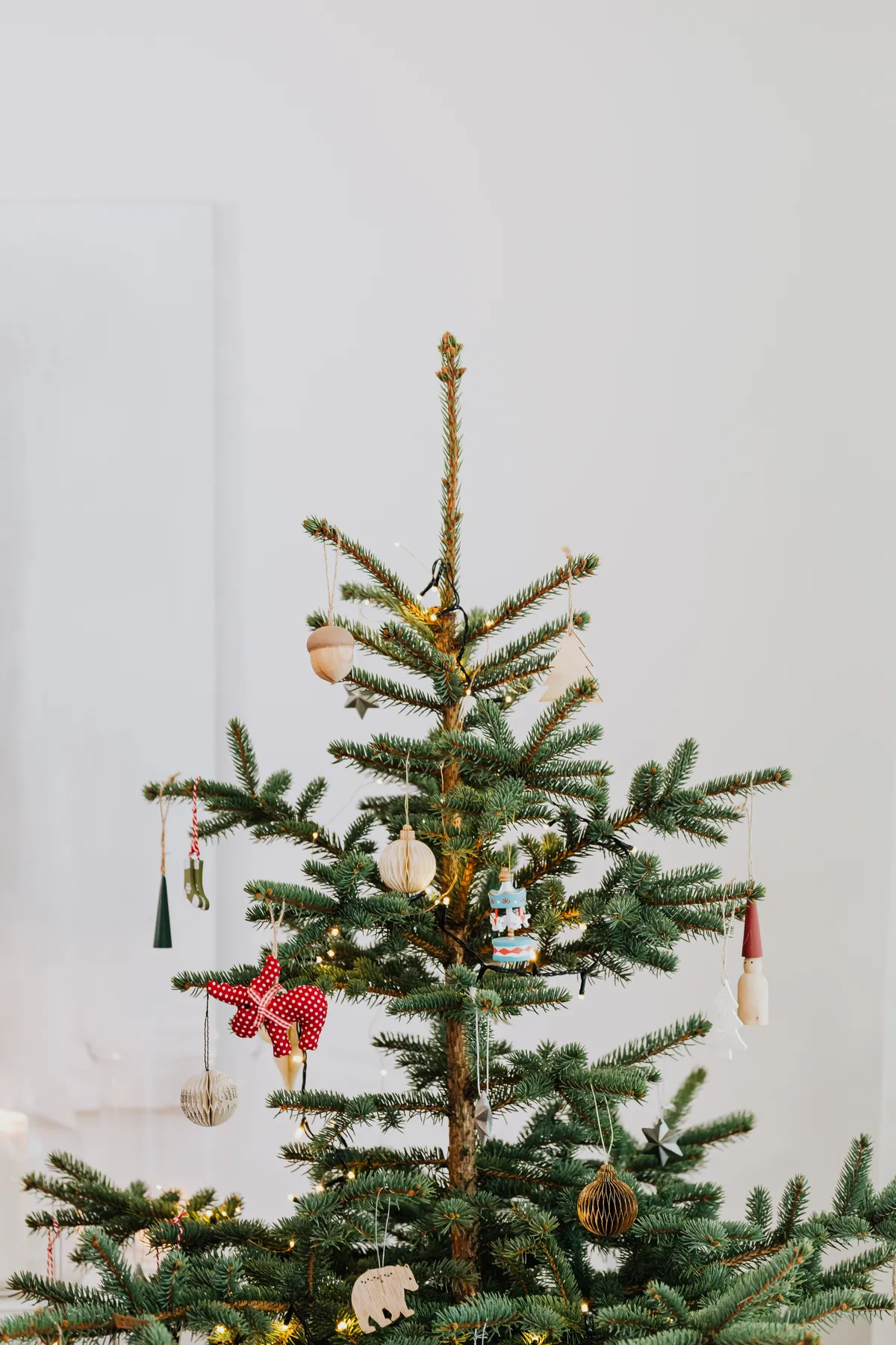 A simple Christmas tree with minimalist decorations and ornaments indoors.