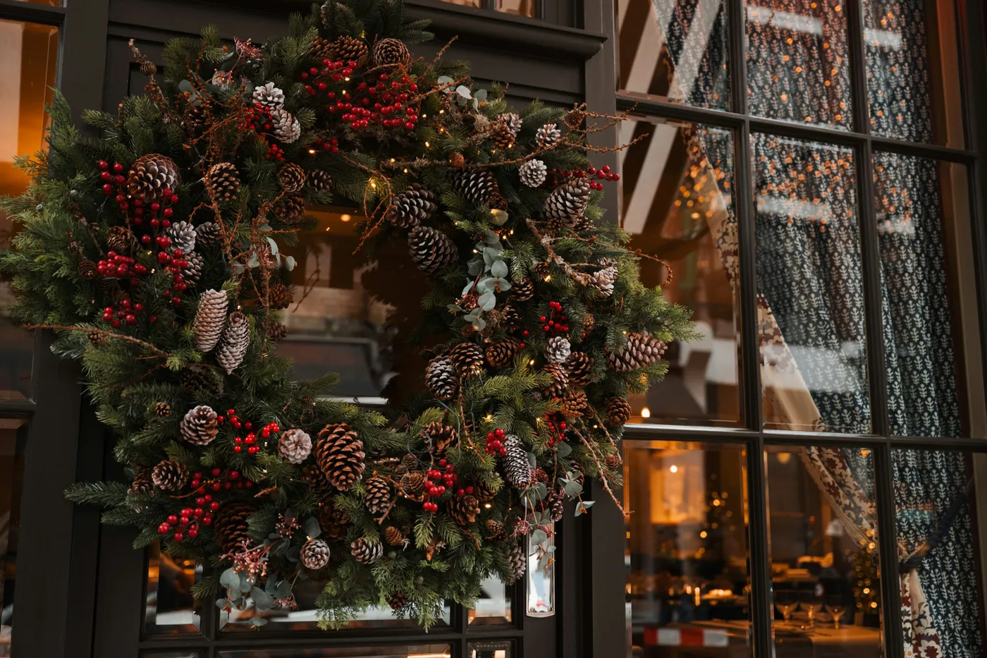 A store window with a christmas wreath and a clock - Free Photo on Unsplash