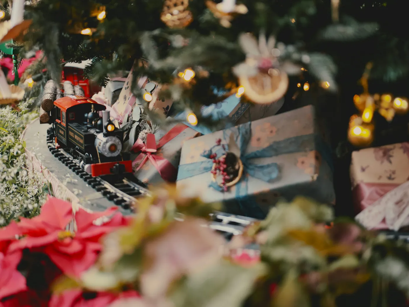 A toy train on a track near a christmas tree - Free Photo on Unsplash