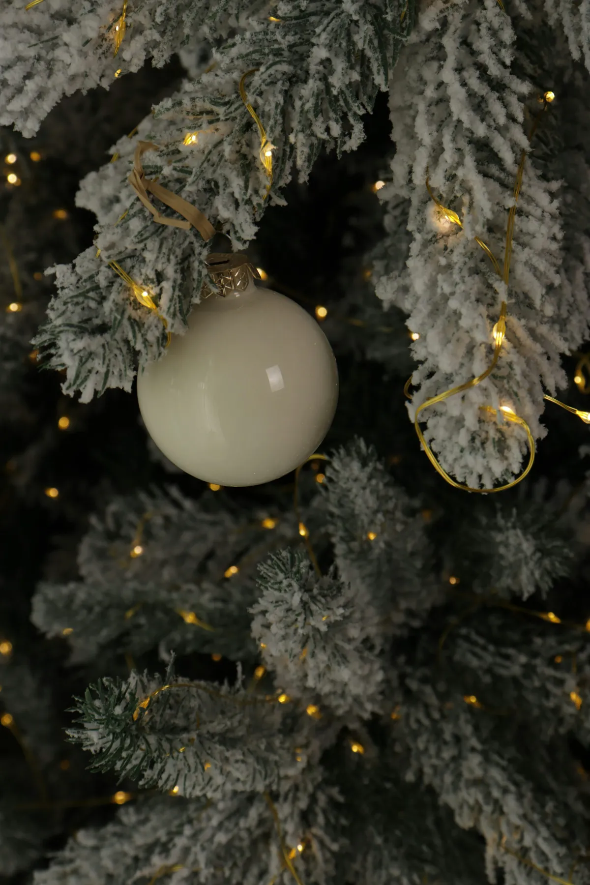 A white ornament hangs on a flocked christmas tree - Free Photo on Unsplash
