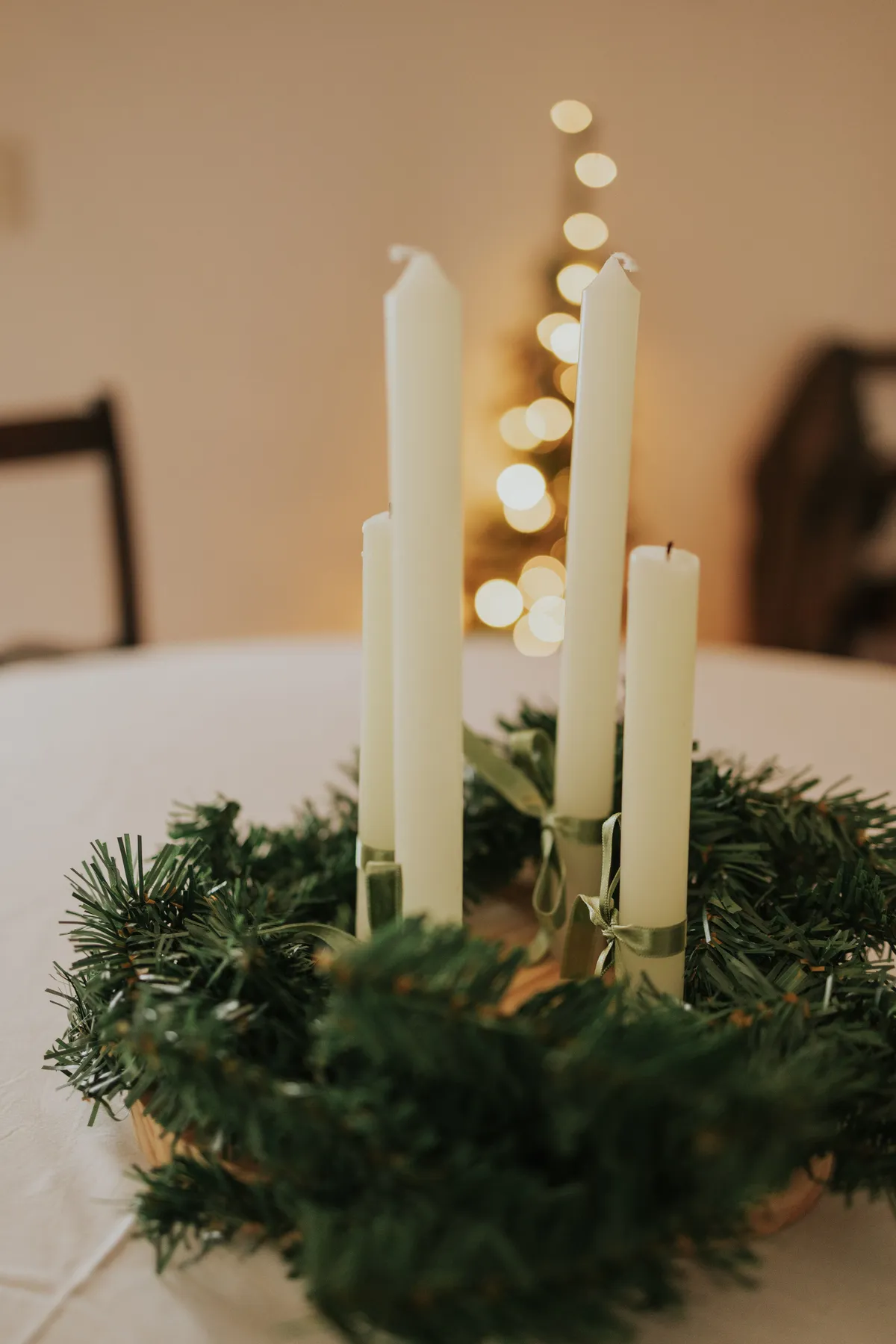 An elegant candle centerpiece with green wreath for festive holiday decor.