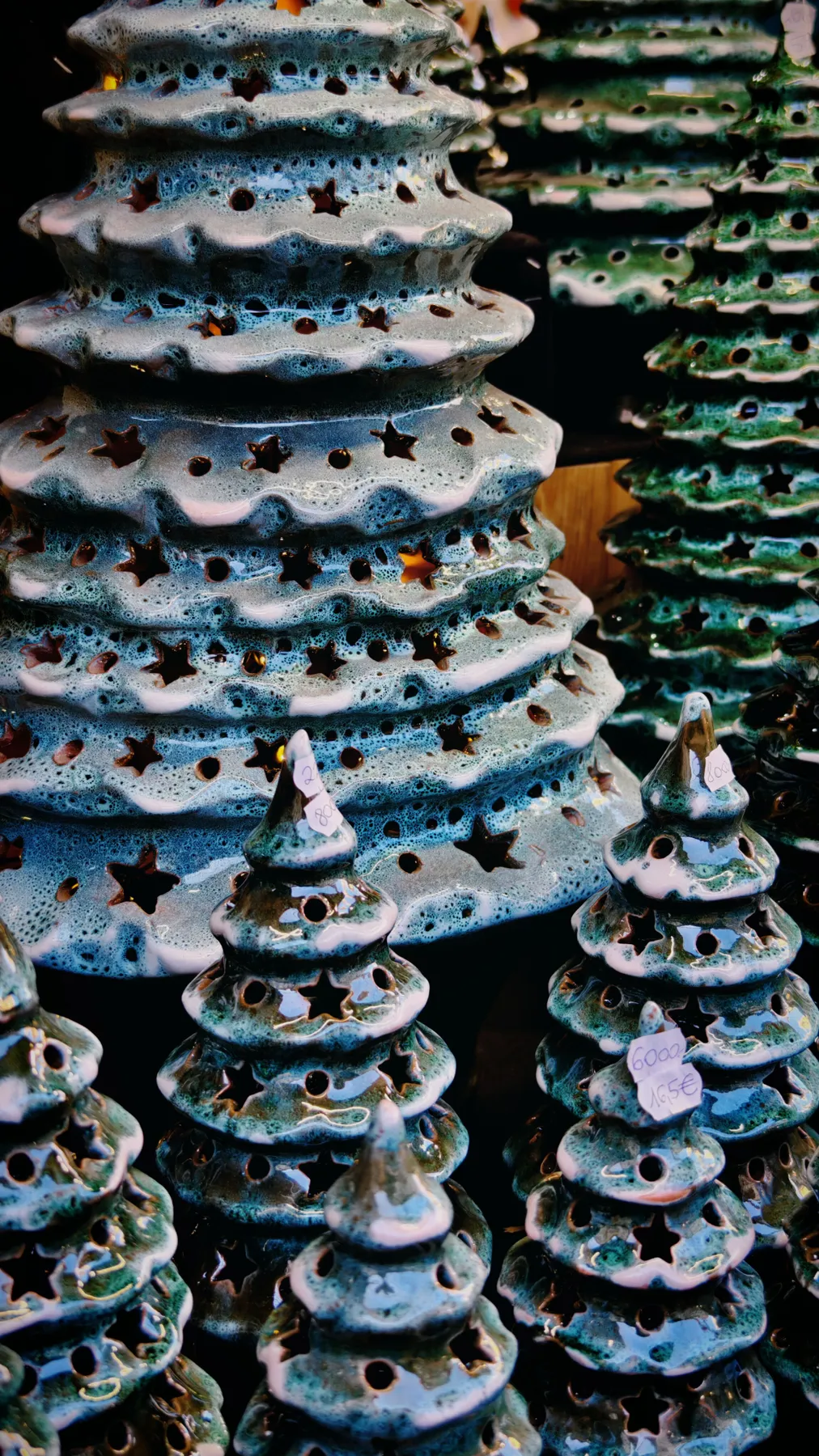 Artistic display of ceramic Christmas trees with star-shaped cutouts, festive decoration.
