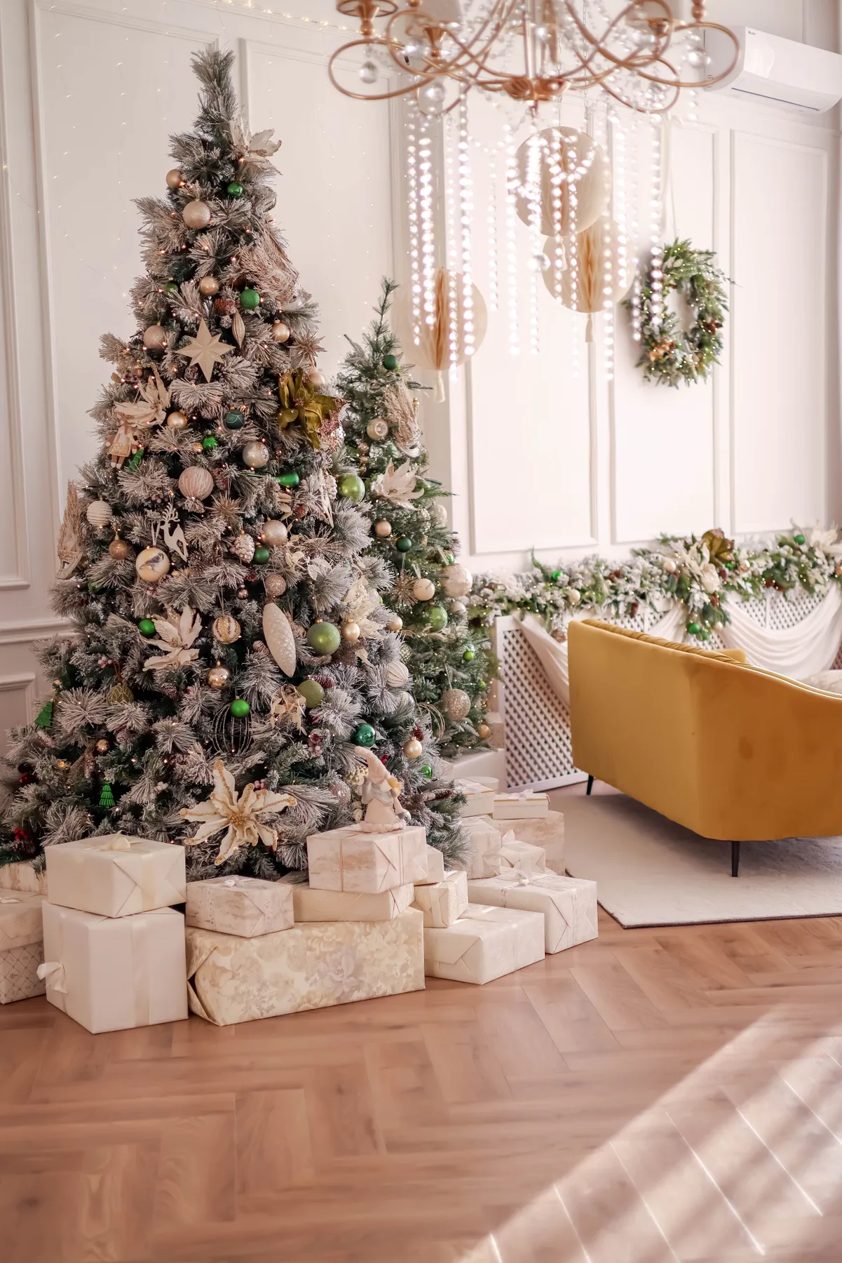 Beautifully decorated Christmas tree in a stylish living room with gifts and a yellow couch.