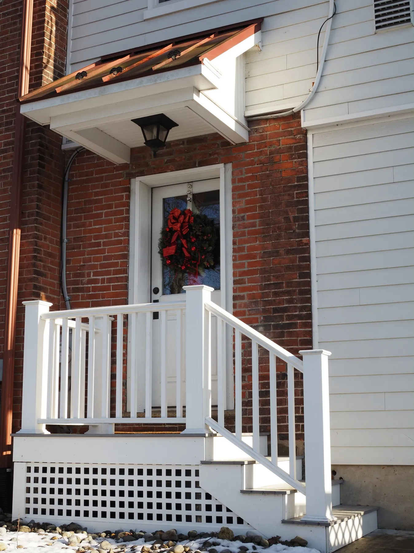 Charming front porch in Doylestown adorned with a festive holiday wreath and bright winter sunlight.