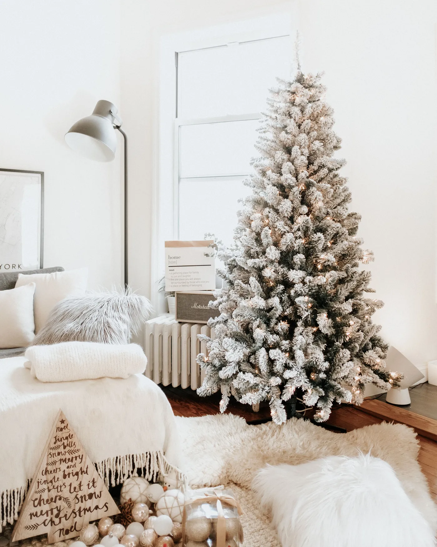 Charming home interior decorated for Christmas with a snow-flocked tree and cozy furnishings.