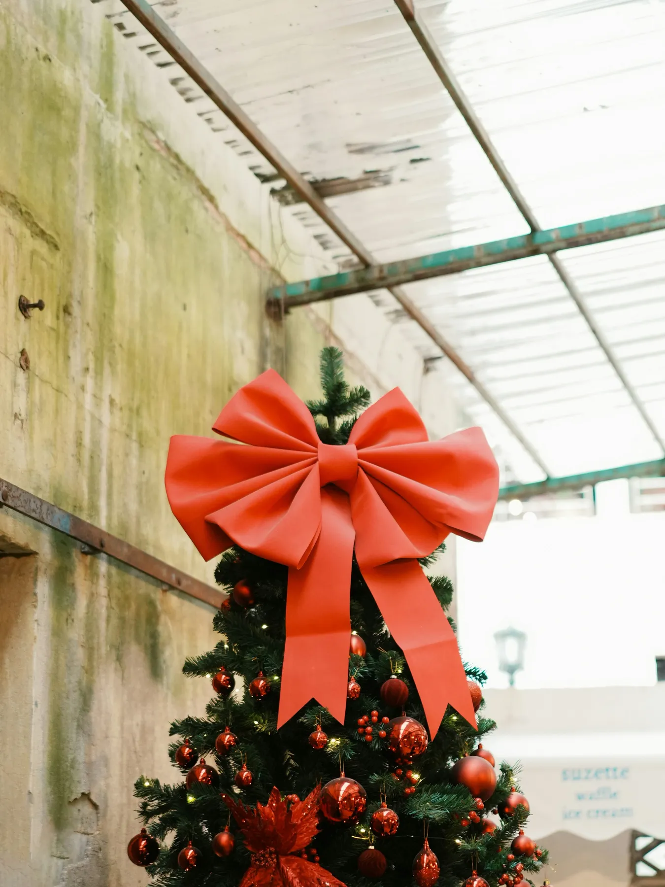 Christmas tree decorated with large red bow and ornaments