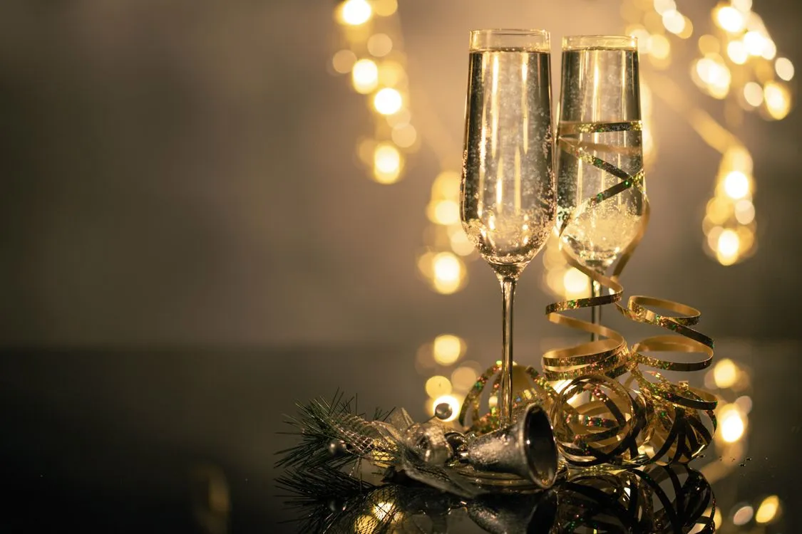 Close-Up Of Two Flute Glasses Filled With Sparkling Wine Wuth Ribbons And  Christmas Decor · Free Stock Photo