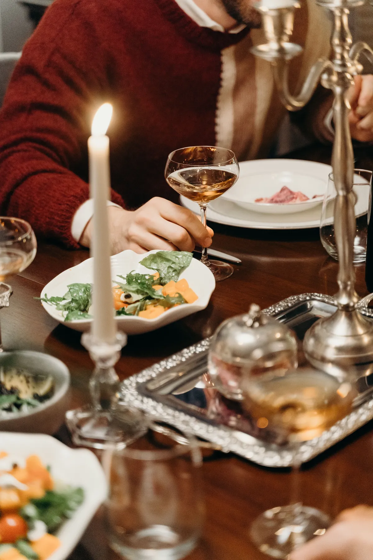 Cozy dinner setting with candlelight and food, capturing warmth and elegance.