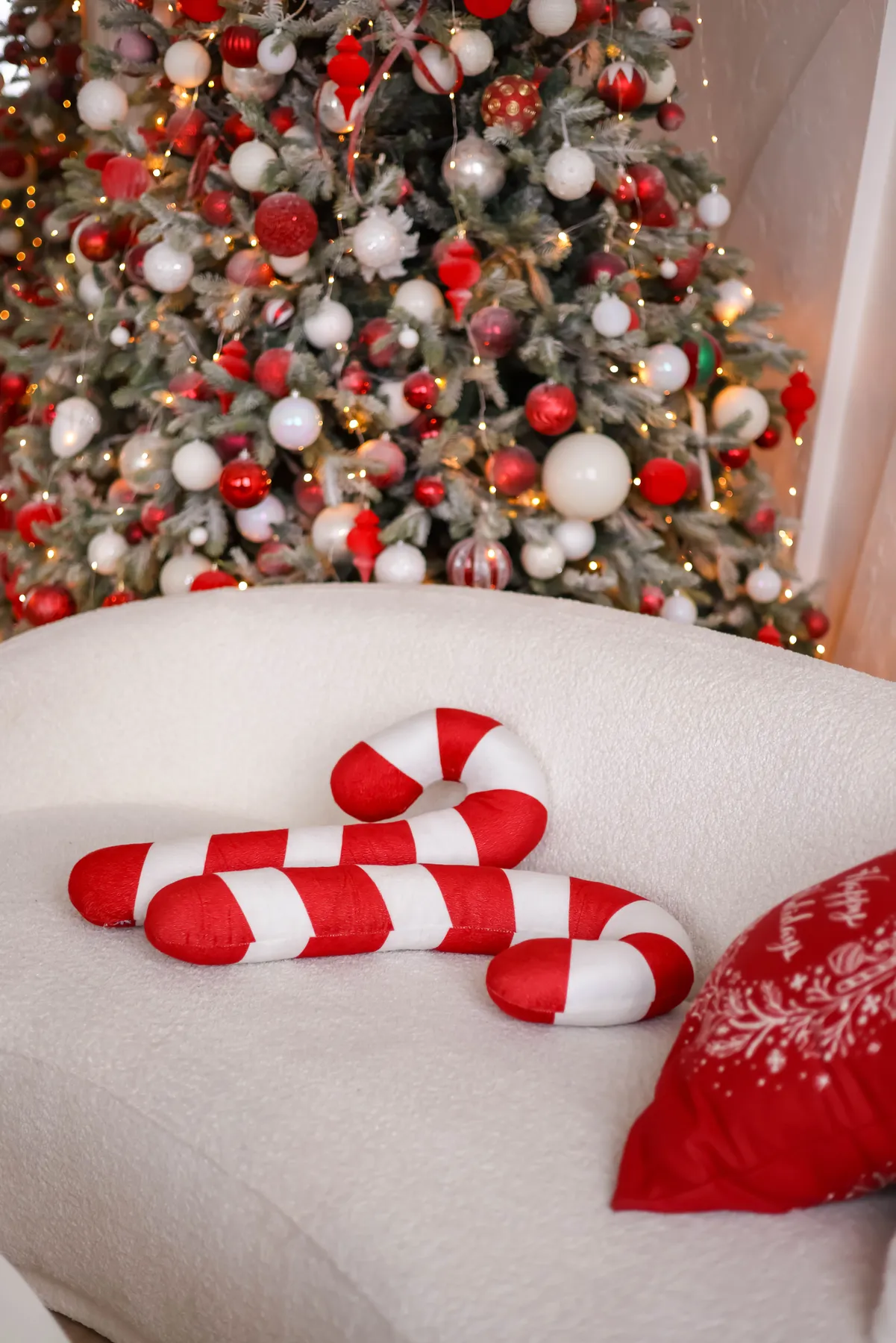 Cozy living room with candy cane pillows and a decorated Christmas tree for the holidays.