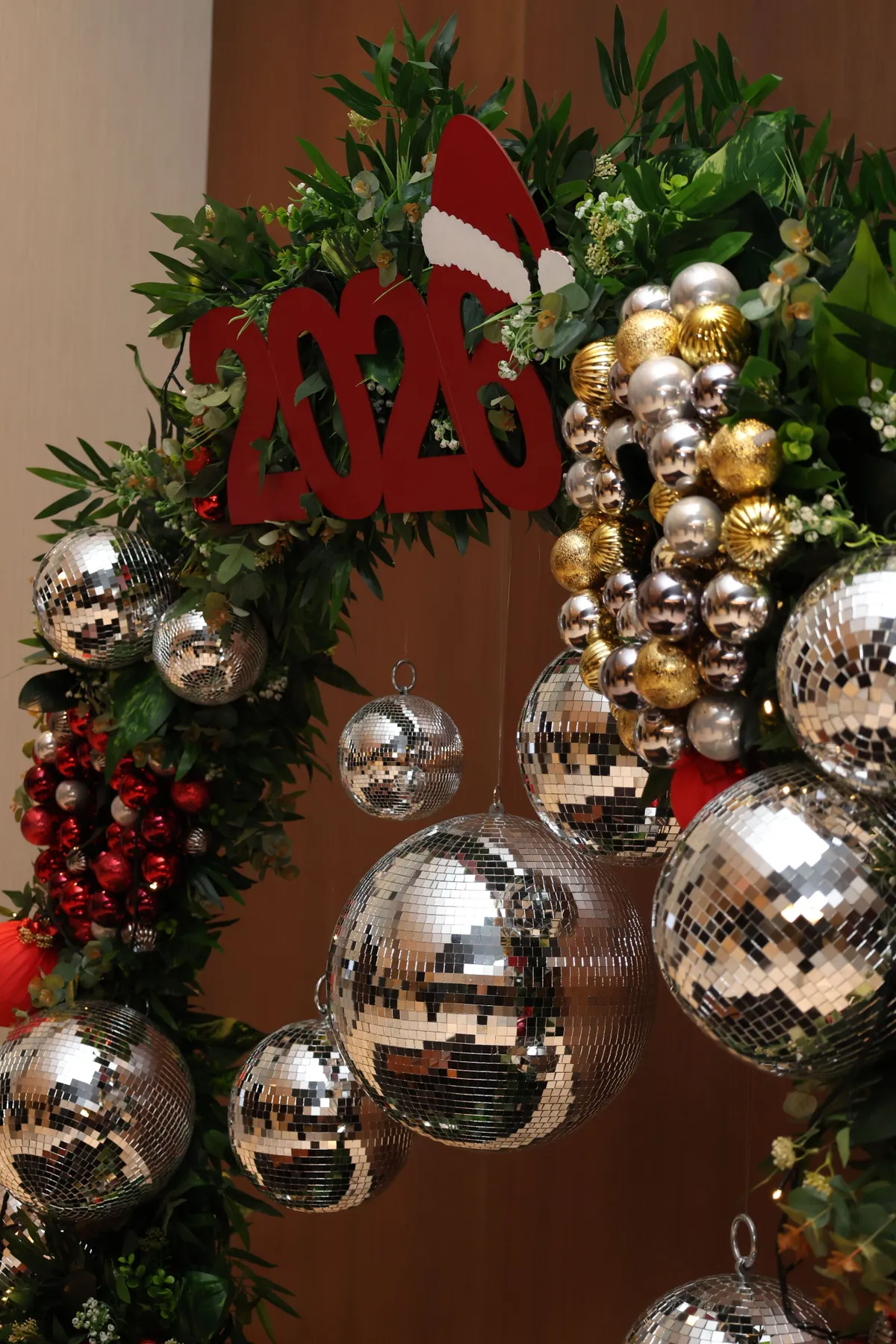 Decorative Christmas wreath adorned with shiny disco balls and festive elements, perfect for holiday ambience.