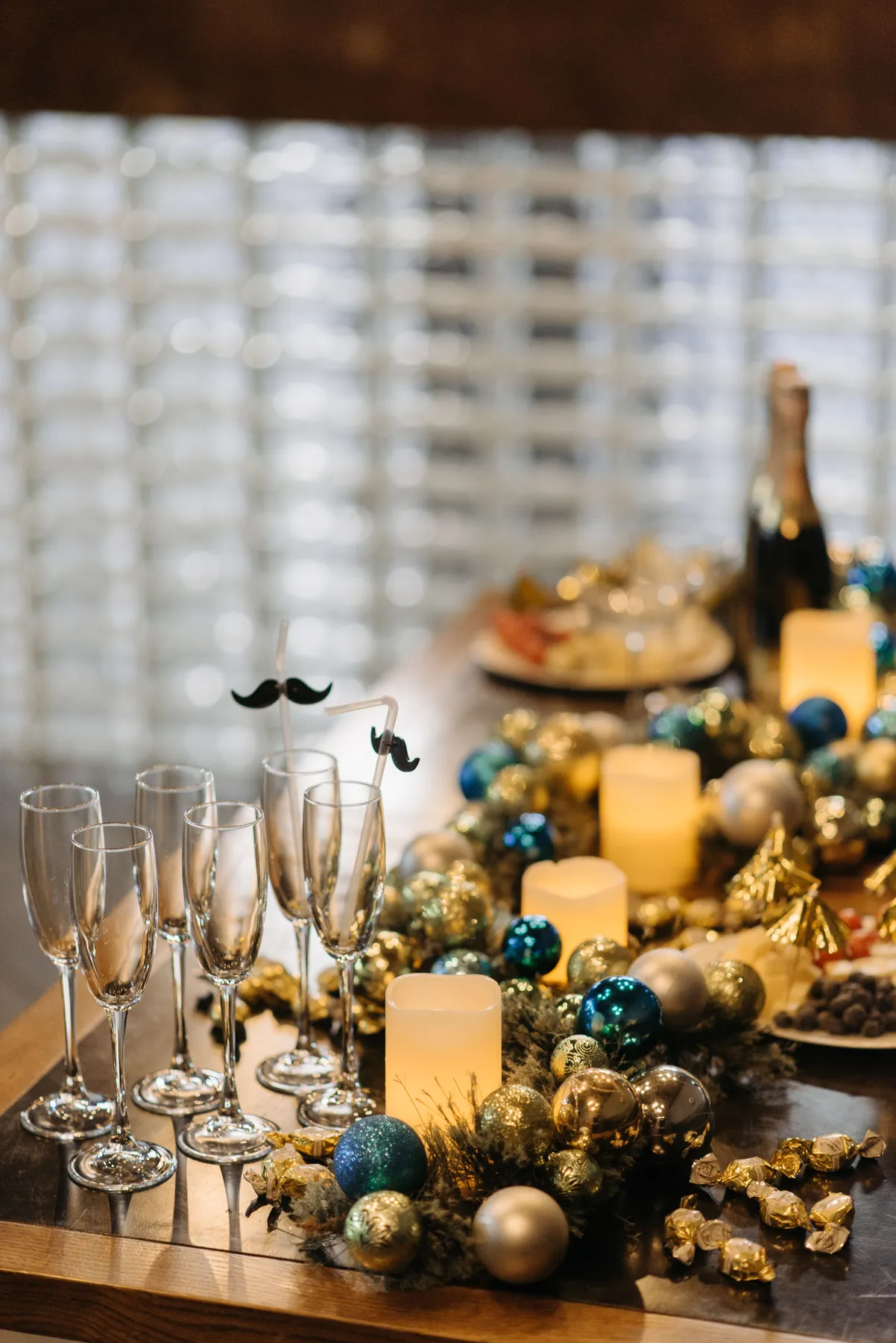 Festive table adorned with candles, champagne, and decorations for a holiday celebration.