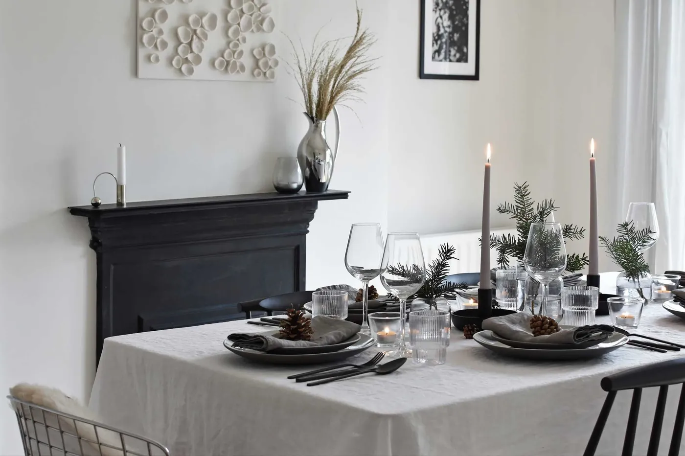 Minimalist Christmas table styling with fir, candles & pine cones |