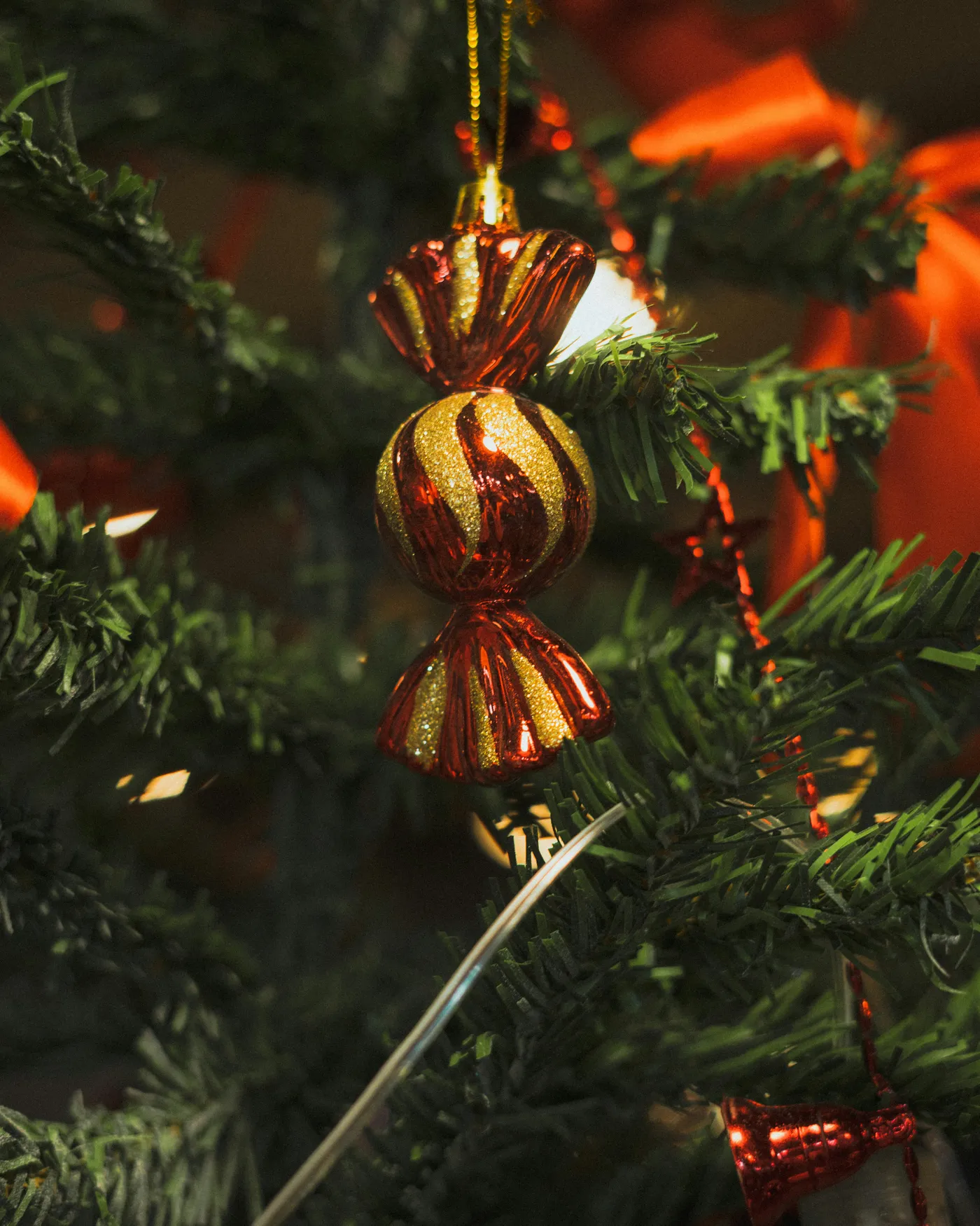 Red and gold striped christmas ornament on tree