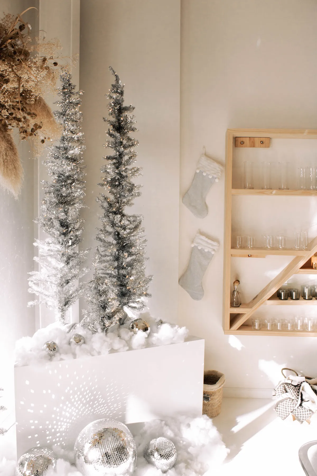 Stylish silver Christmas decorations with shimmering trees and stockings in a cozy indoor setting.